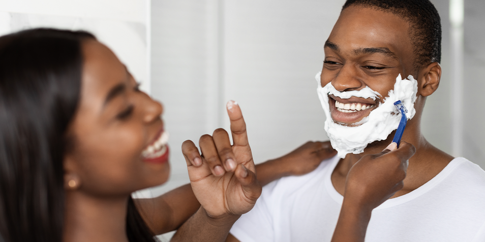 A man getting a beard shave from his woman