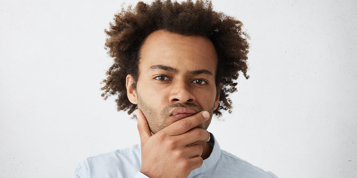 A man holding his beard.