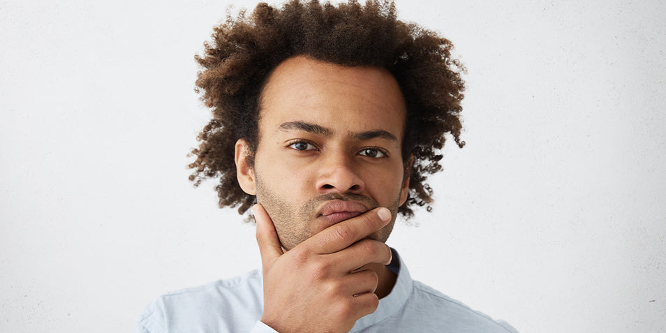 A man holding his beard.